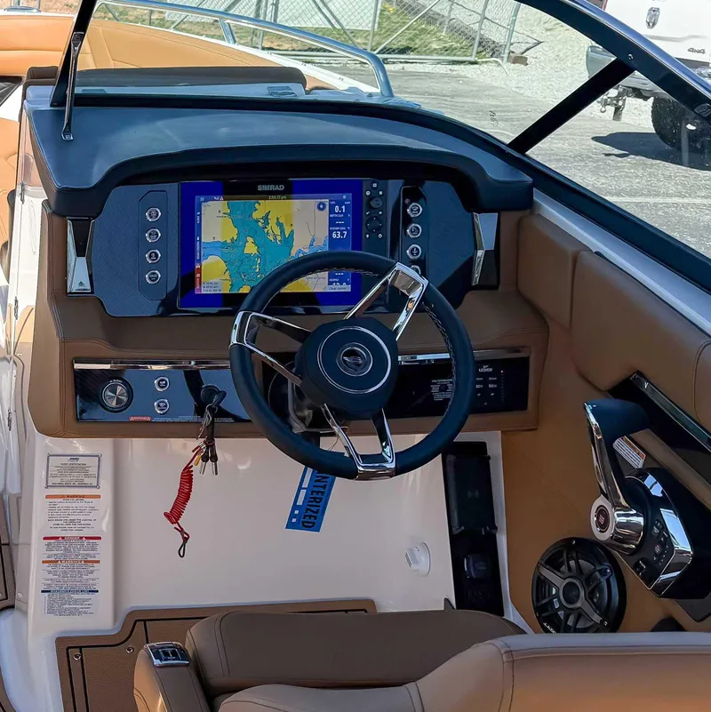 Slide: The Image of 2025 Chaparral 267 SSX boat dashboard with navigation display and steering wheel. - 17
