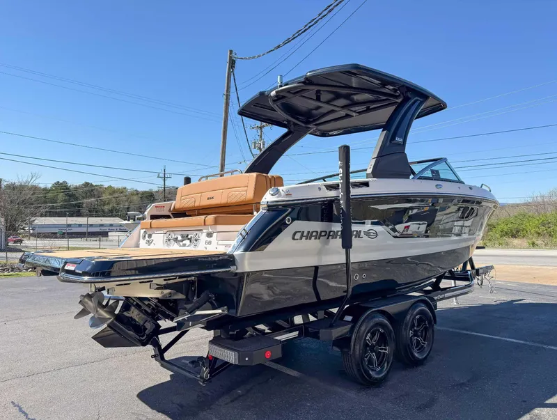 Slide: The Image of 2025 Chaparral 267 SSX boat on trailer, sleek design, black and white exterior. - 7