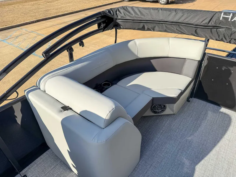 Slide: The Image of 2025 Harris Cruiser 230 CWDH boat interior with gray seating and speaker system. - 18