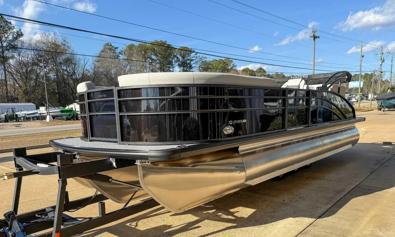 Slide: The Image of 2025 Harris Cruiser 230 CWDH pontoon boat on trailer, parked outdoors. - 4