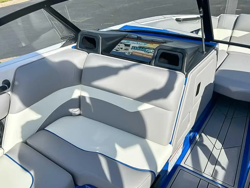 Slide: The Image of 2024 Moomba Mojo boat interior with gray and white seating, blue accents, and dashboard display. - 16