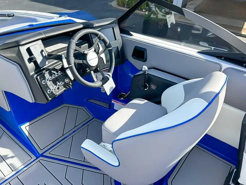 Slide: The Image of 2024 Moomba Mojo boat interior with modern steering wheel and sleek blue accents. - 17