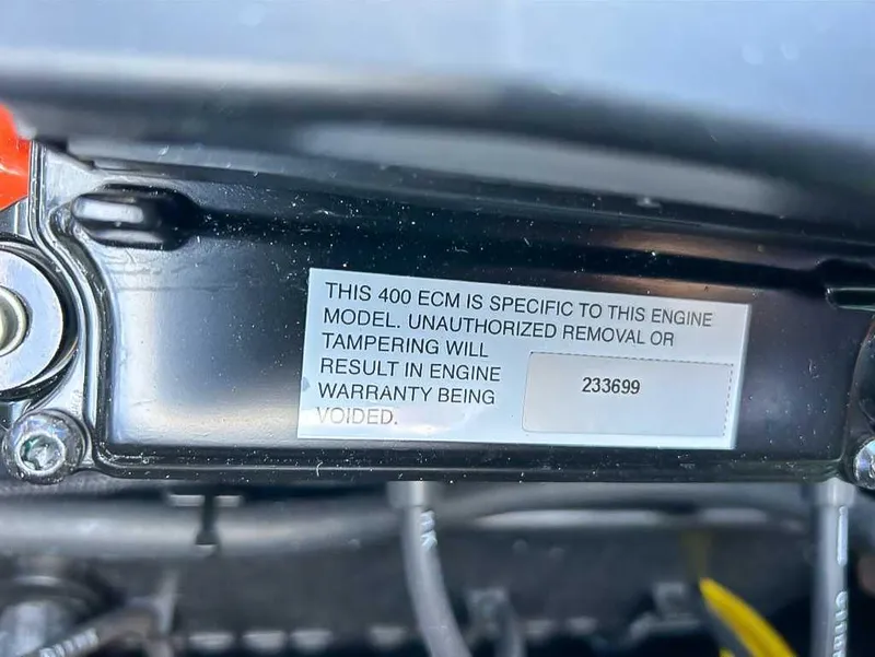 Slide: The Image of 2024 Moomba Mojo engine ECM warning label about warranty voiding due to tampering. - 22