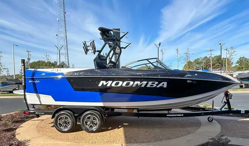 Slide: The Image of 2024 Moomba Mojo boat with blue and black design on a trailer, parked outdoors. - 6