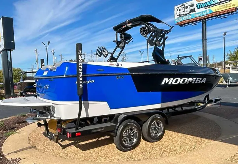 Slide: The Image of 2024 Moomba Mojo boat on trailer, blue and white design, displayed outdoors. - 7