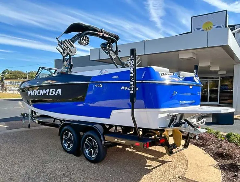 Slide: The Image of 2024 Moomba Mojo boat in blue and white on a trailer outside a building. - 8