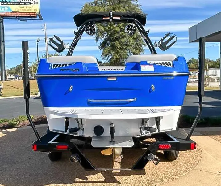 Slide: The Image of 2024 Moomba Mojo boat, blue exterior, rear view with speakers and swim platform. - 9