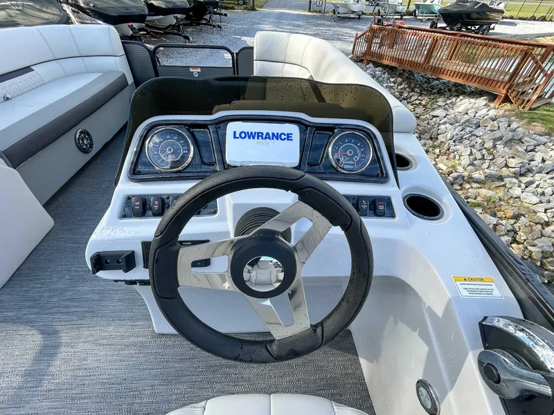 Slide: The Image of 2022 Godfrey Sweetwater boat dashboard with steering wheel and Lowrance display. - 11