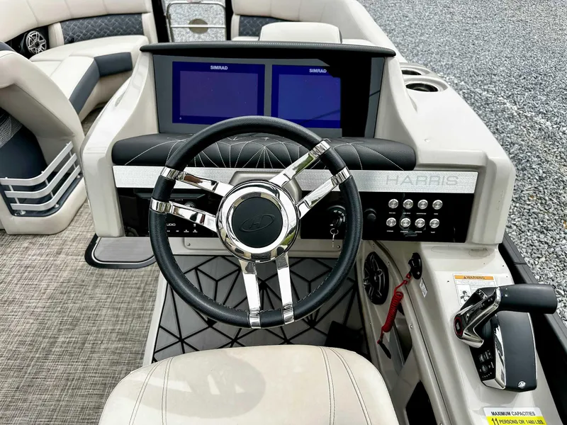 Slide: The Image of 2023 Harris Grand Mariner 230 boat dashboard with dual Simrad displays and modern steering wheel. - 19