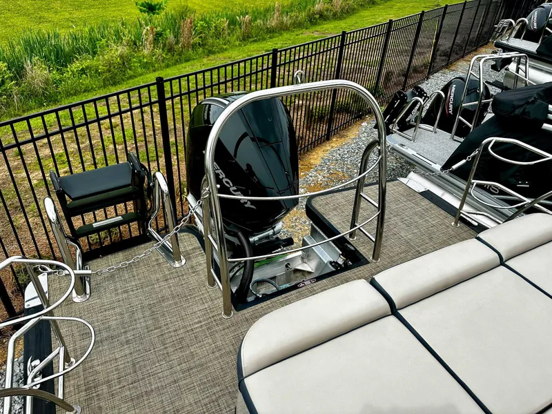 Slide: The Image of 2023 Harris Grand Mariner 230 pontoon boat with Mercury outboard motor, docked near a fence. - 22