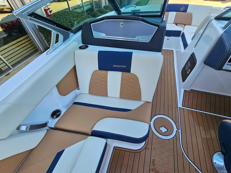 Slide: The Image of 2021 MasterCraft X22 boat interior with tan and white seating, wood-style flooring. - 12