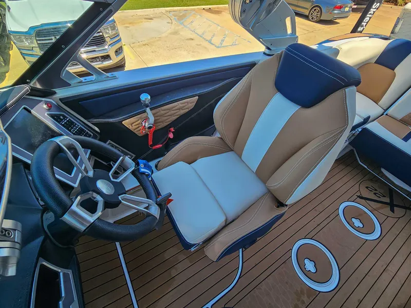 Slide: The Image of 2021 MasterCraft X22 boat interior with luxury seating and modern steering wheel design. - 13