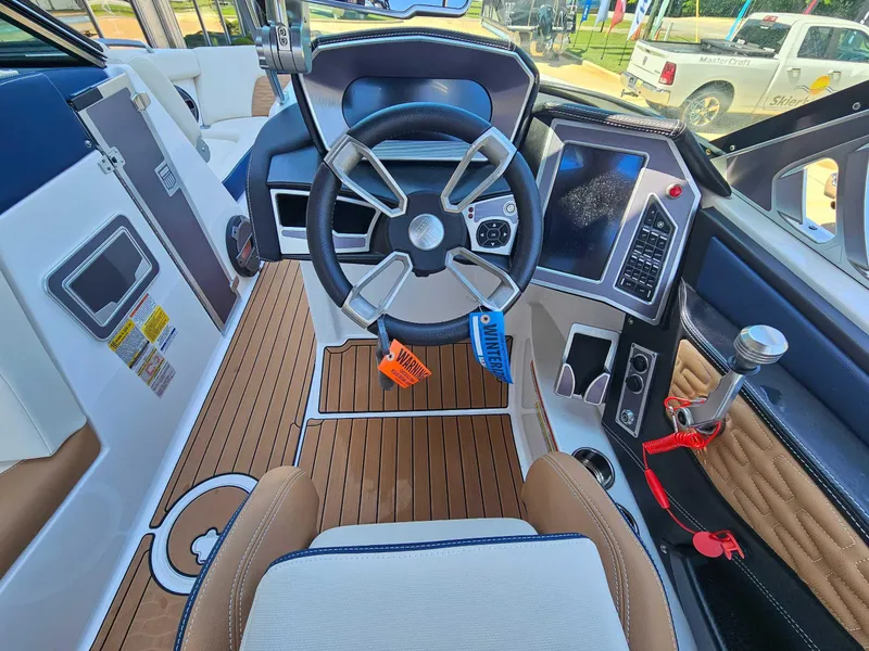 Slide: The Image of 2021 MasterCraft X22 boat cockpit with modern steering wheel and control panel. - 14