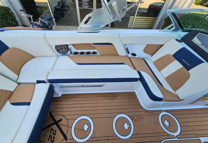Slide: The Image of 2021 MasterCraft X22 boat interior with luxurious seating and teak flooring. - 17