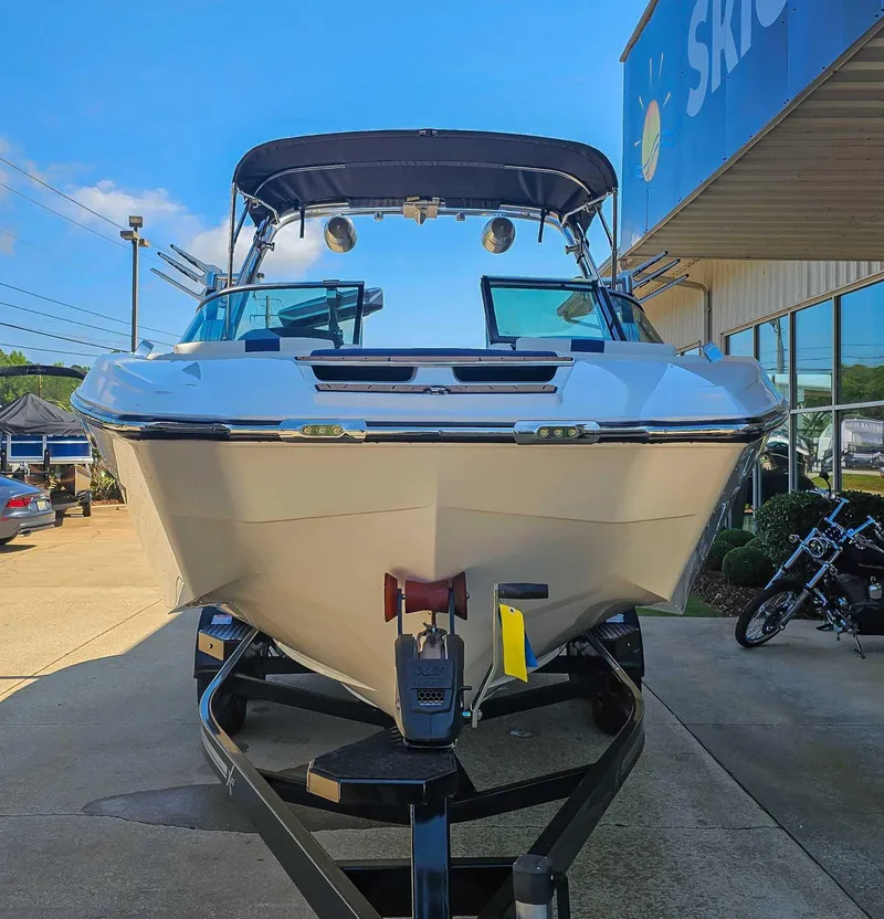 Slide: The Image of 2021 MasterCraft X22 boat on trailer outside dealership, sunny day. - 4