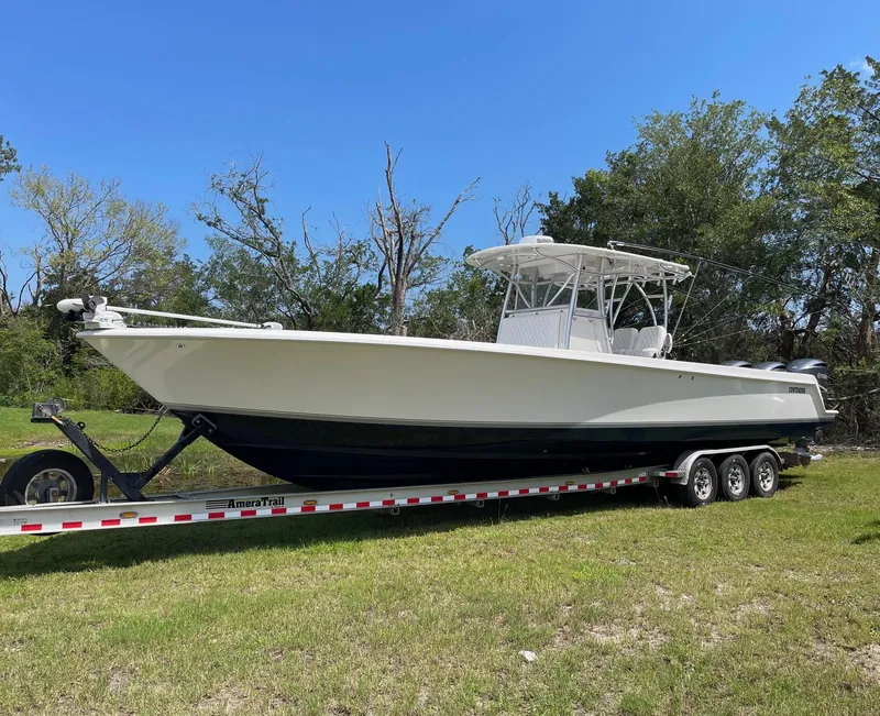 Slide: The Image of 2009 Contender 39 Tournament boat on trailer, parked on grass with trees in background. - 0
