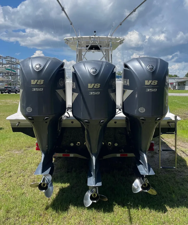 Slide: The Image of Triple Yamaha V8 350 engines on a 2009 Contender 39 Tournament boat under a cloudy sky. - 3