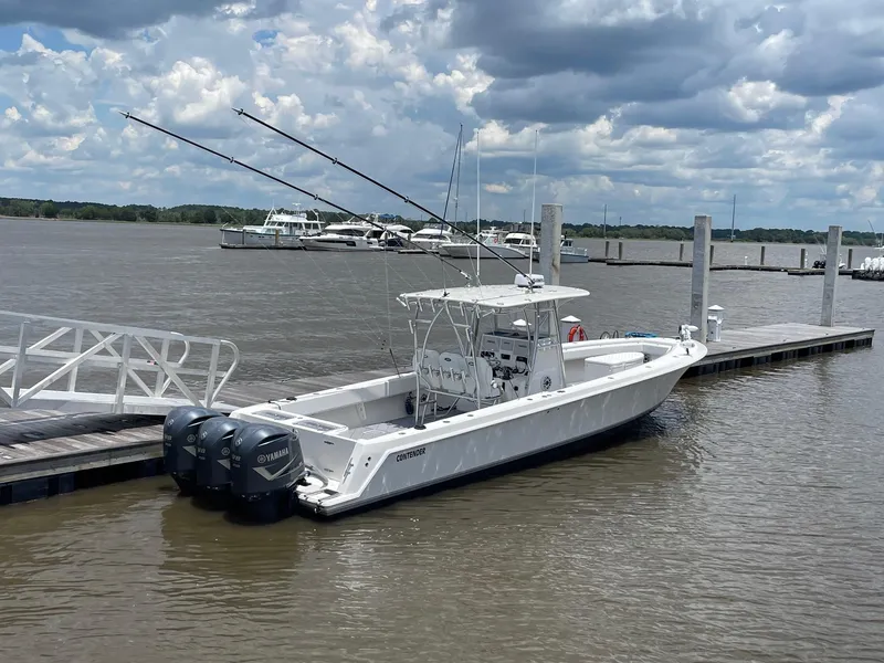 Slide: The Image of 2009 Contender 39 Tournament boat docked with triple Yamaha engines under cloudy sky. - 5