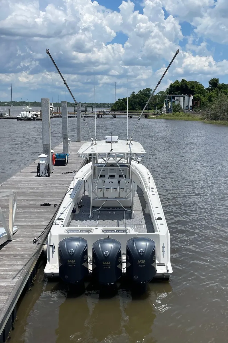 Slide: The Image of 2009 Contender 39 Tournament boat docked, featuring triple Yamaha V8 engines under a cloudy sky. - 6