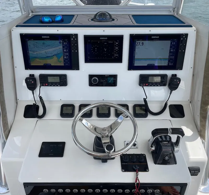 Slide: The Image of Control panel of a 2009 Contender 39 Tournament boat with navigation screens and steering wheel. - 7