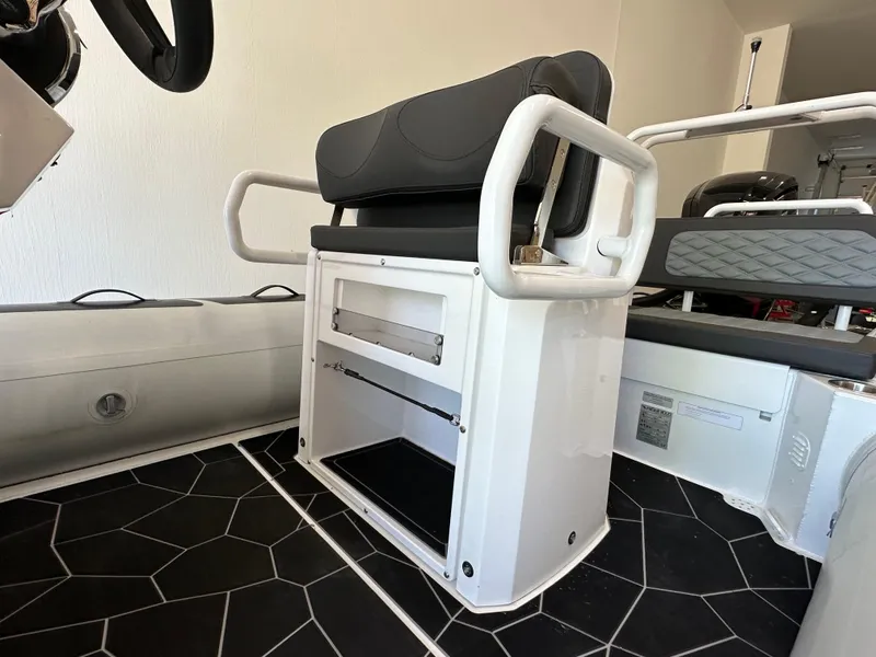 Slide: The Image of 2025 Highfield Sport 560 boat interior with black cushioned seating and geometric flooring. - 11