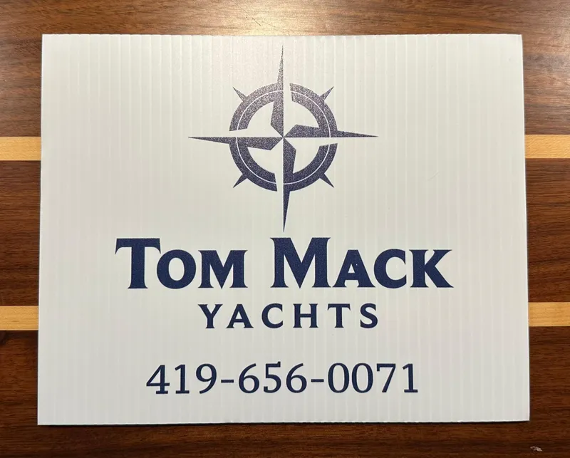 Slide: The Image of Tom Mack Yachts sign with contact number, featuring a nautical compass logo. - 18