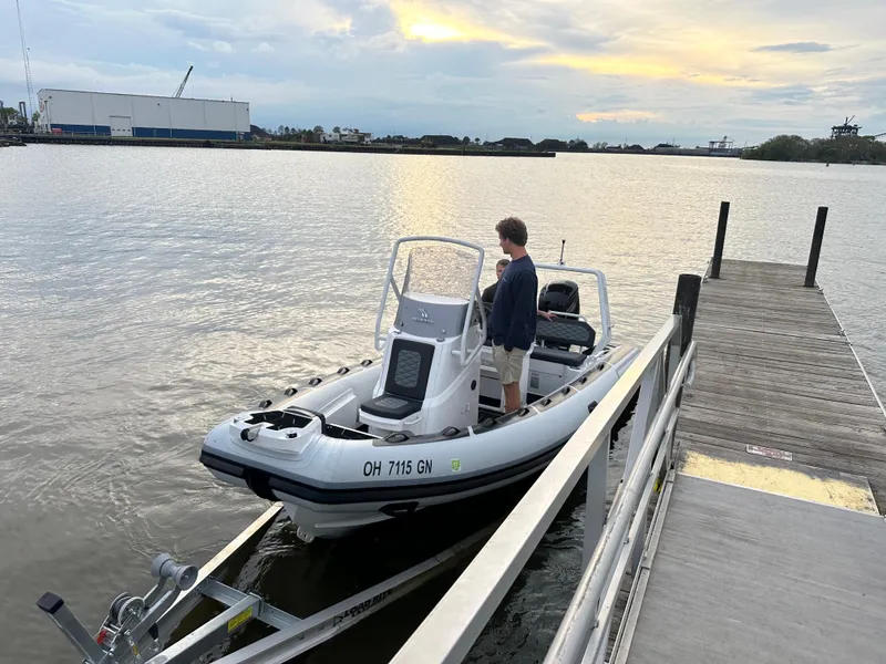 Slide: The Image of 2025 Highfield Sport 560 boat docked at a pier during sunset. - 7