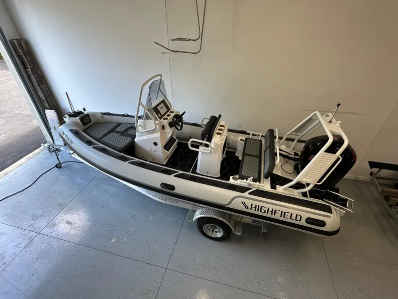 Slide: The Image of 2025 Highfield Sport 560 boat in garage, side view, on trailer. - 9