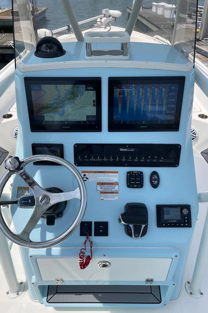 Slide: The Image of 2022 Pathfinder 2600 TRS boat dashboard with dual screens and steering wheel. - 10
