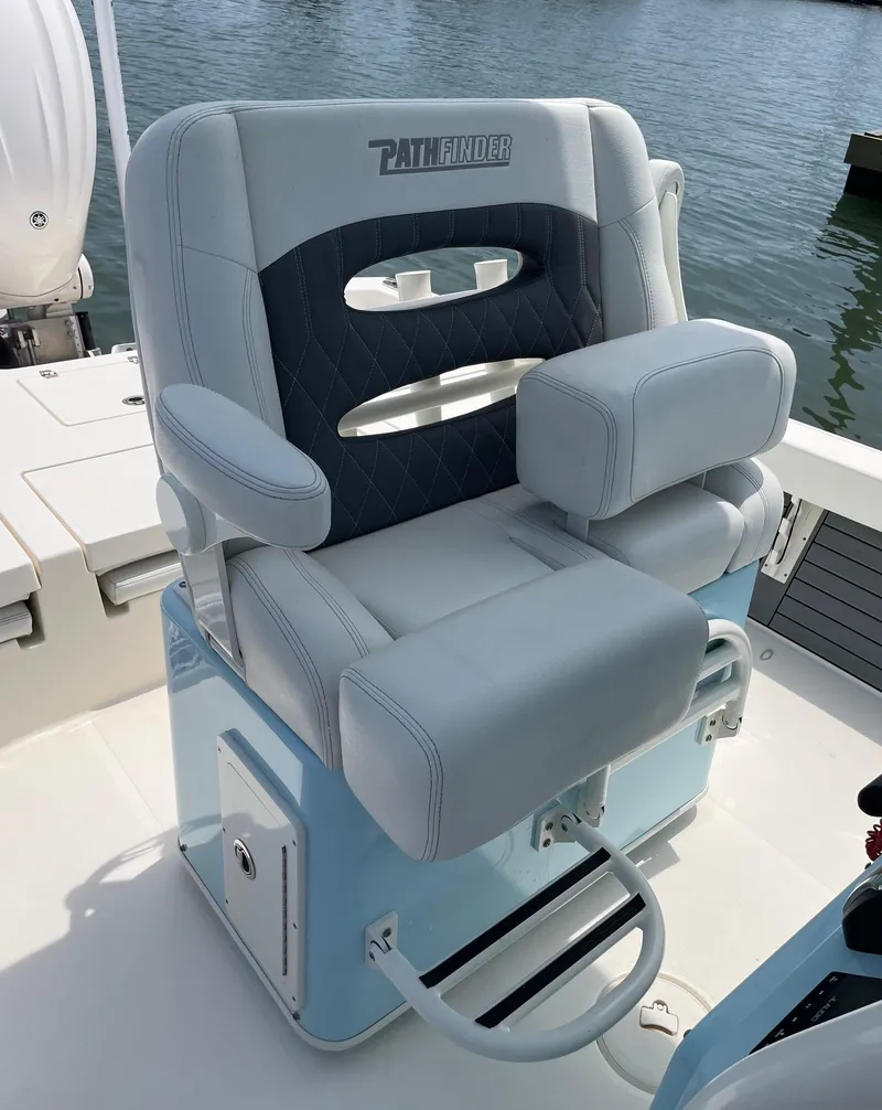 Slide: The Image of 2022 Pathfinder 2600 TRS boat seat, gray and blue, on a sunny day by the water. - 14