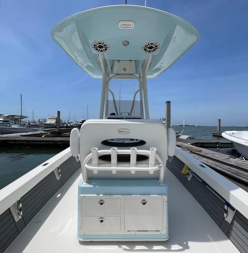 Slide: The Image of 2022 Pathfinder 2600 TRS boat at marina, featuring center console and rod holders. - 16