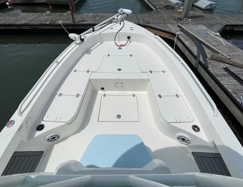 Slide: The Image of 2022 Pathfinder 2600 TRS boat deck with storage compartments and seating at a marina. - 18