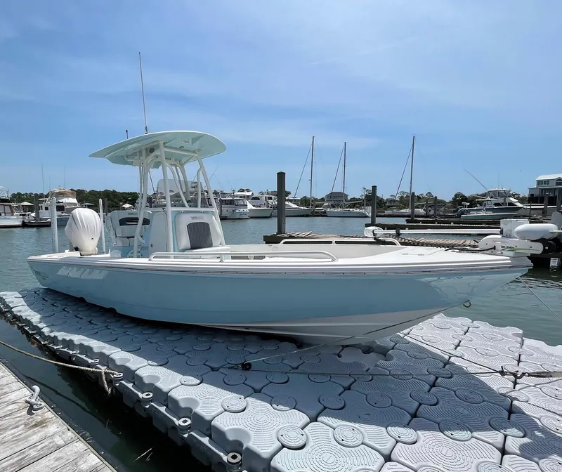 Slide: The Image of 2022 Pathfinder 2600 TRS boat docked at marina under clear blue sky. - 2