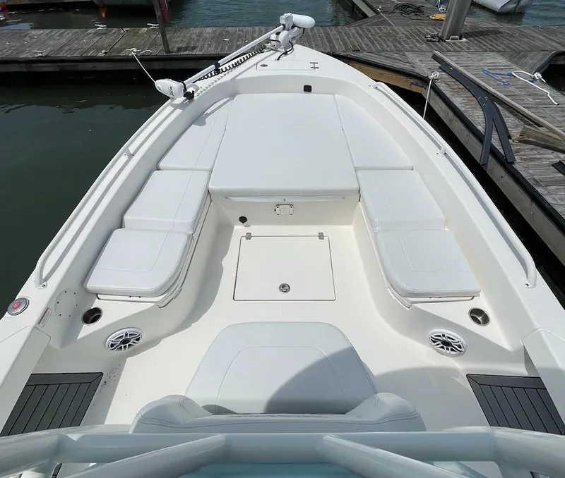 Slide: The Image of 2022 Pathfinder 2600 TRS boat interior with cushioned seating and storage, docked at marina. - 20