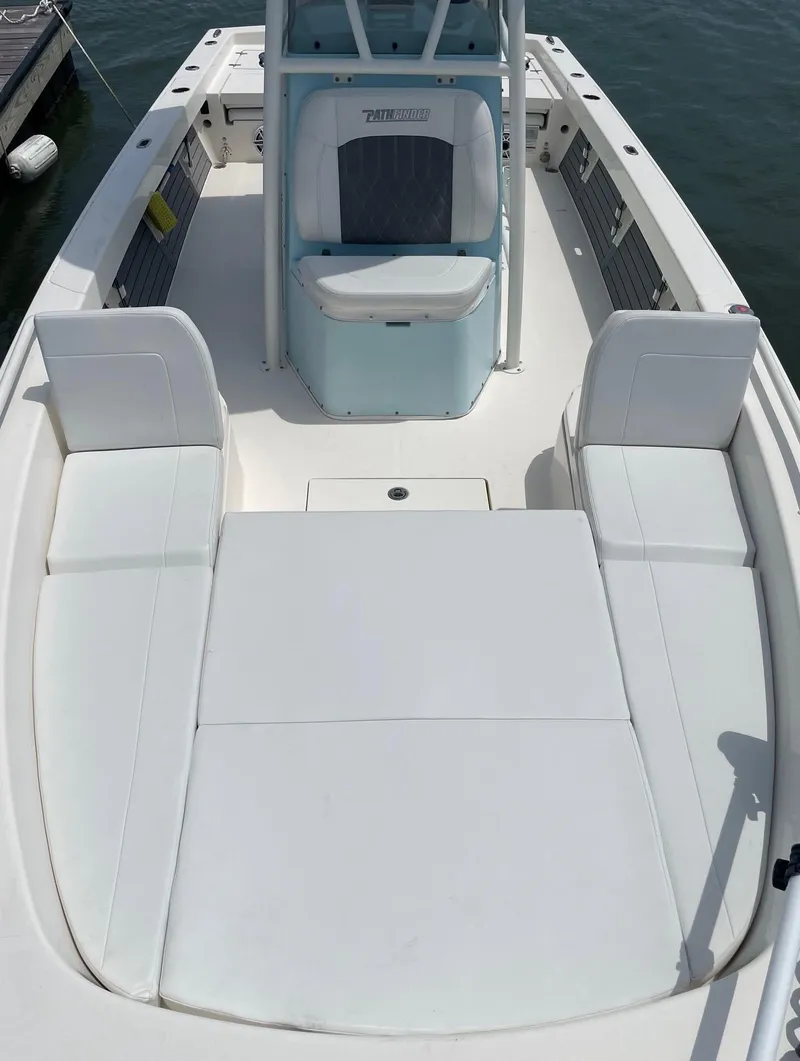 Slide: The Image of 2022 Pathfinder 2600 TRS boat with white seating and center console on water. - 22