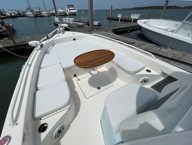 Slide: The Image of 2022 Pathfinder 2600 TRS boat with spacious seating and wooden table at marina. - 23