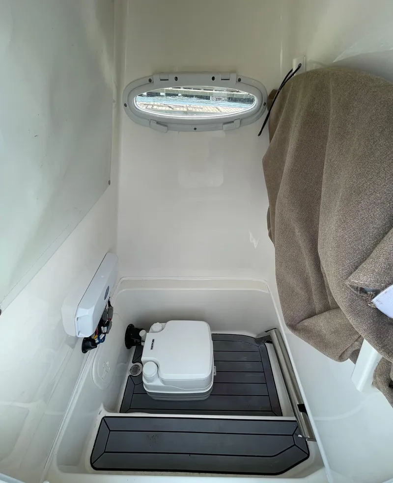 Slide: The Image of 2022 Pathfinder 2600 TRS boat interior with compact toilet and window. - 32