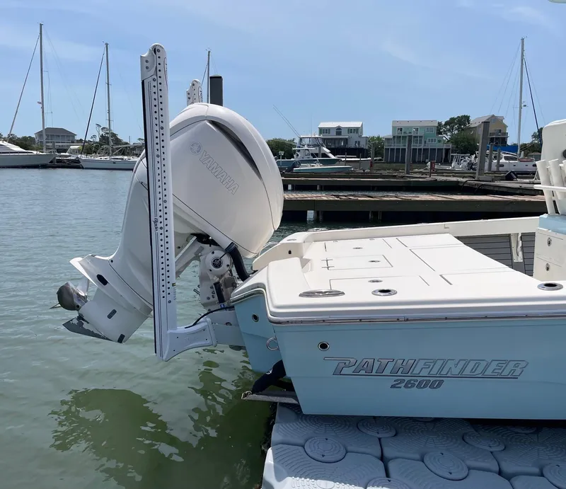 Slide: The Image of 2022 Pathfinder 2600 TRS boat docked, featuring a powerful outboard motor. - 6
