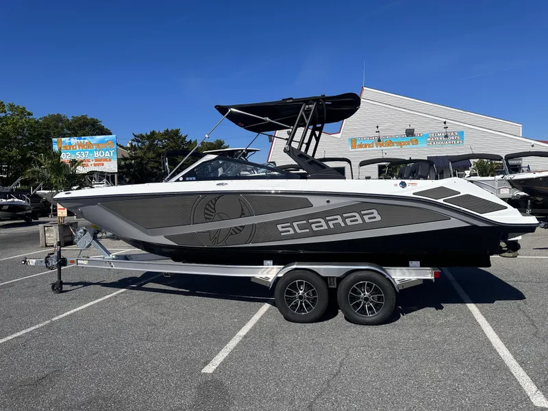 The Image of 2025 Scarab 235 LX boat on trailer in parking lot, sunny day. - 0