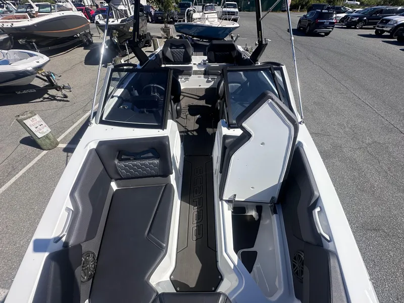 Slide: The Image of 2025 Scarab 235 LX boat interior with modern seating and dashboard, parked in a marina. - 10