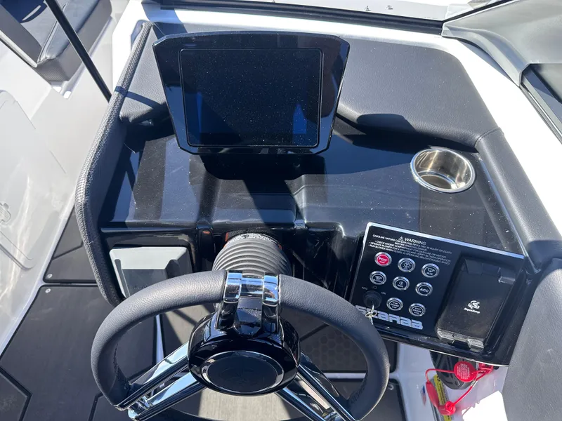 Slide: The Image of 2025 Scarab 235 LX boat dashboard with steering wheel, touchscreen, and control panel. - 12
