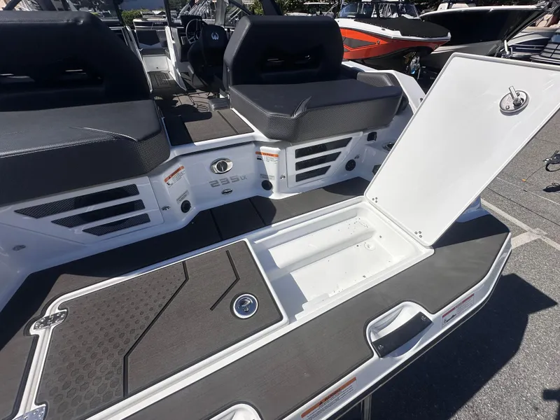 Slide: The Image of 2025 Scarab 235 LX boat interior with open storage compartment and seating. - 16