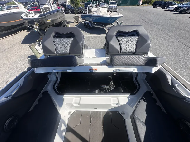 Slide: The Image of 2025 Scarab 235 LX boat interior with dual seats and open storage compartment. - 17