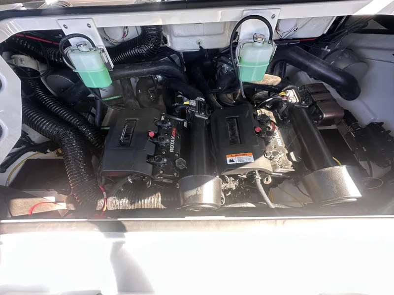 Slide: The Image of Engine compartment of a 2025 Scarab 235 LX boat, showcasing dual motors and components. - 18