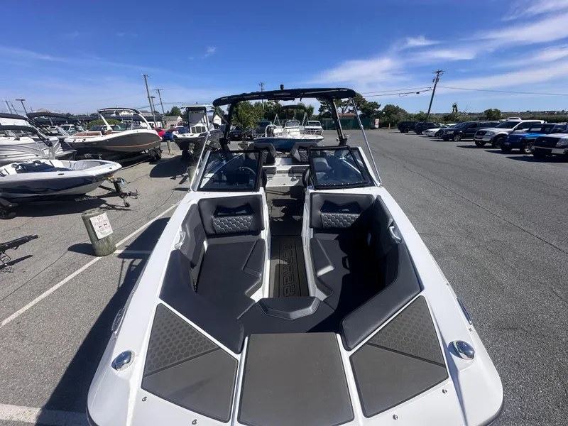 Slide: The Image of 2025 Scarab 235 LX boat in parking lot, showcasing sleek design and spacious seating. - 9