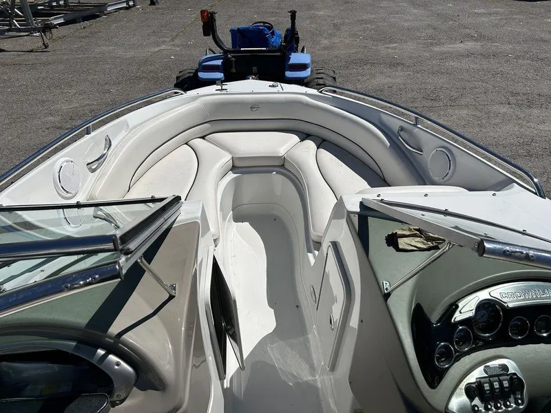Slide: The Image of 2011 Crownline 220LS boat interior with white seating and dashboard controls. - 19