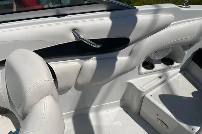 Slide: The Image of Interior of a 2011 Crownline 220LS boat, featuring white seating and cup holders. - 34
