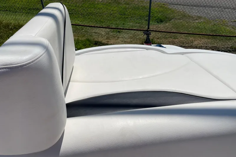 Slide: The Image of White leather seating on a 2011 Crownline 220LS boat, outdoors. - 42