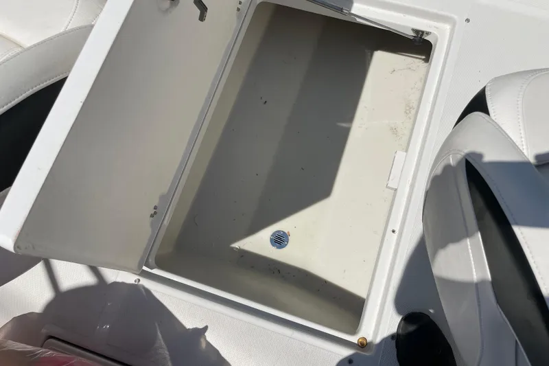 Slide: The Image of Open storage compartment on a 2011 Crownline 220LS boat, featuring white interior. - 43