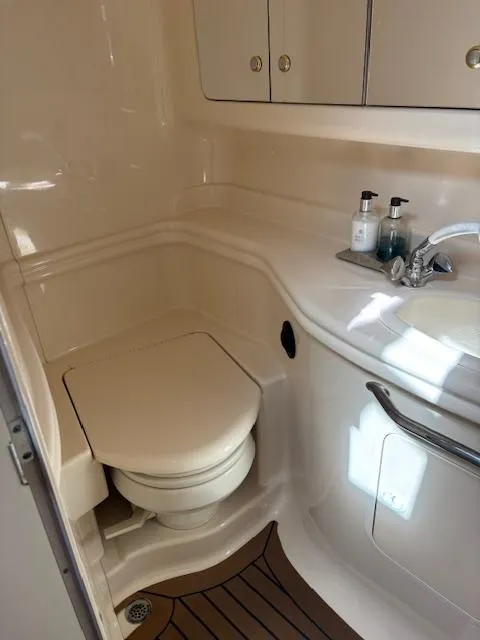 Slide: The Image of 2003 Sea Ray 340 Sundancer bathroom with toilet, sink, and storage cabinets. - 11